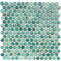 a blue and white mosaic tile with circles on the bottom, in shades of green