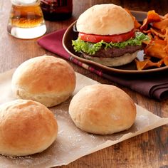 three hamburgers and some chips on a table