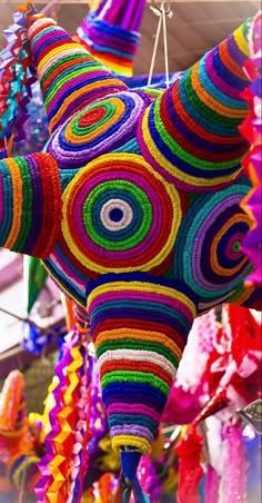 an elephant made out of yarn and other colorful items hanging from it's sides