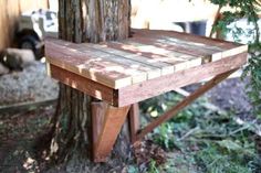 a wooden bench sitting next to a tree