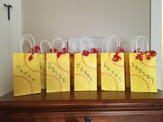 small yellow bags with red bows are sitting on a dresser