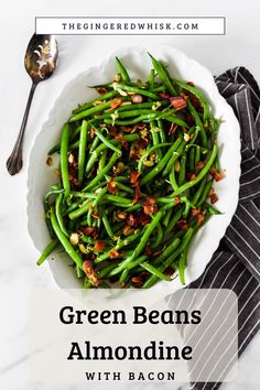 green beans with bacon in a white bowl on top of a marble table next to a spoon