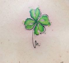 a clover tattoo on the back of a woman