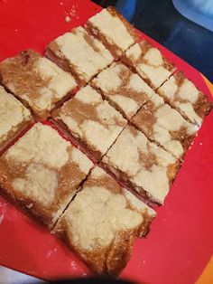 several squares of food sitting on top of a red cutting board