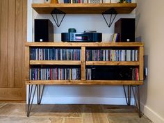 a wooden shelf filled with lots of different types of records and audio equipment on top of it