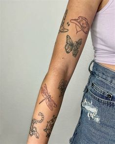 a woman's arm with tattoos on her left arm and butterflies on the right arm