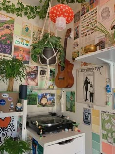 a room filled with lots of plants and pictures on the wall next to a record player