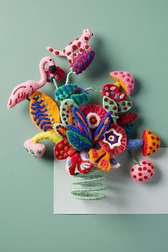 a bouquet of flowers made out of crochet on a white piece of paper