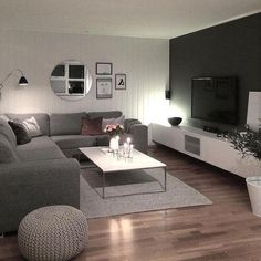 a living room filled with furniture and a flat screen tv on top of a wooden floor