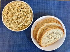 two white bowls filled with bread on top of a blue place mat