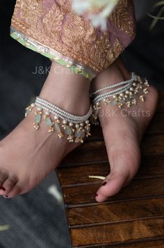 Our Multi-layered pearl anklets are handcrafted with love and strewn with semi-precious pearl and mint stone hangings. This chic pair of anklets will wrap beautifully around your ankles and lend an edgy design to your attire. Elevate your style with our enchanting pearl anklets and let your beauty shine. Closure - Lobster Weight - 76gm (pair) Elegant White Festive Anklet, Handmade Anklets For Festivals And Parties, Elegant Handmade Festive Anklets, Elegant Handmade Anklets With Round Beads, Elegant Handmade Anklets With Beads, Semi Precious Stone Jewelry, Tassel Anklet, Anklets Indian, Wedding Flower Jewelry