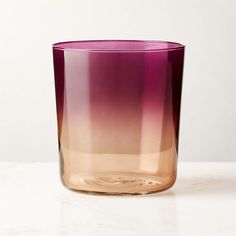 a pink and purple vase sitting on top of a white table