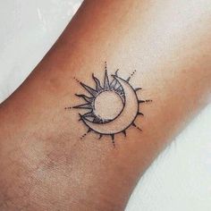 a small sun and moon tattoo on the wrist is shown in black ink with white background