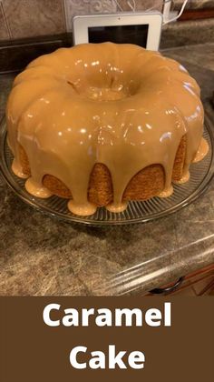 a cake sitting on top of a glass plate covered in caramel icing next to a microwave