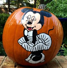 a mickey mouse pumpkin sitting on top of a wooden table