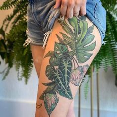 a woman's legs with tattoos and flowers on them