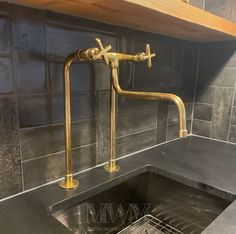 a sink in a kitchen under a shelf with a faucet and drainer