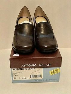 This is a pair of Antonio Melani Classic Pump new in box Size 9N, the color is café with 2.50 inch heel. They are made in Brazil comfy inner soles with leather soles with non-skid nubs. Brown Slip-on Heels For Office, Brown Square Toe Heels With Rubber Sole, Office Slip-on Brown Heels, Brown Leather Shoes With Square Toe And Medium Width, Brown Leather Shoes With Medium Width And Square Toe, Formal Leather Slip-on Shoes With Deep Heel Cup, Formal Heels With Medium Width And Plain Toe, Brown Loafers For Formal Occasions, Medium Width Plain Toe Heels For Formal Occasions