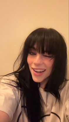 a woman with long black hair is smiling