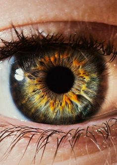 an extreme close up shot of the iris of a person's blue and yellow eye