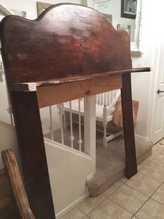 an old wooden bed frame in the corner of a room with tile flooring and white walls