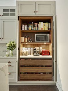 an open cabinet in the middle of a kitchen