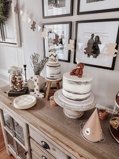 a table topped with cakes and desserts on top of wooden countertop next to framed pictures