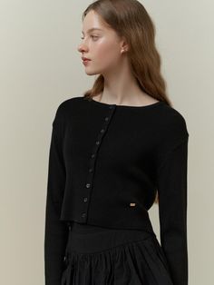 This is a classic cardigan with a simple, chic design. It has a round neckline and a full button placket with small, evenly spaced buttons. The cardigan is designed with a fitted silhouette and long sleeves, suggesting a snug and comfortable fit. A small, discreet logo or emblem is visible on the front, indicating a touch of branding.- Round neckline and full button placket are key features.- Fitted silhouette with long sleeves.- A subtle logo embellishes the front of the cardigan. Chic Button-up Fine Knit Cardigan, Chic Fine Knit Button-up Cardigan, Elegant Button-up Sweater, Elegant Solid Color Button-up Sweater, Chic Cardigan With Button Closure, Chic Daywear Cardigan With Buttons, Chic Solid Cardigan With Button Closure, Chic Cardigan With Buttons For Daywear, Elegant Crew Neck Cardigan For Layering