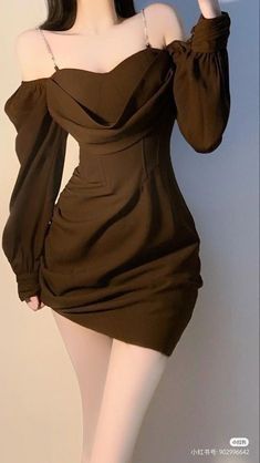 a woman in a brown dress posing for the camera with her hand on her hip