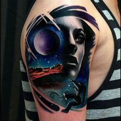 a woman's arm with an abstract tattoo design on it, and a space scene in the background