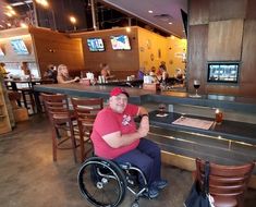 a man in a wheel chair sitting at a bar