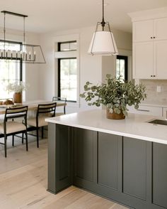 a kitchen with an island, sink and dining room table in the backround