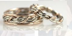 two gold and silver wedding rings on top of each other, one with an intertwined design