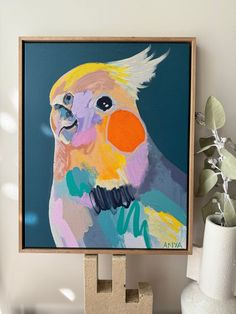 a painting of a colorful parrot on a wall next to a potted plant and vase