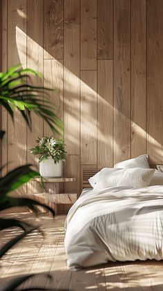 a bed with white sheets and pillows in a room next to a plant on the floor