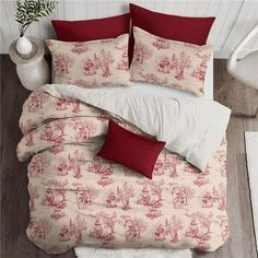 a bed with red and white pillows on top of it