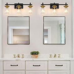 two mirrors are above the double sinks in this white bathroom with gold trimmings