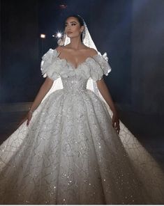 a woman in a white wedding dress standing on a stage