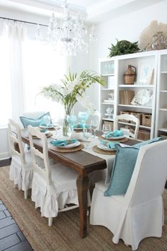 the dining room table is set with blue and white plates, napkins, and place settings