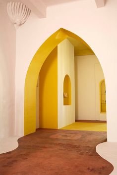 an empty room with yellow walls and arches