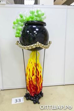 a black vase with yellow and red flames in it sitting on top of a table