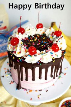 a birthday cake with sprinkles and cherries is on a white plate