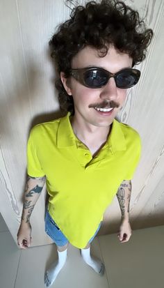 a man wearing sunglasses and a yellow shirt