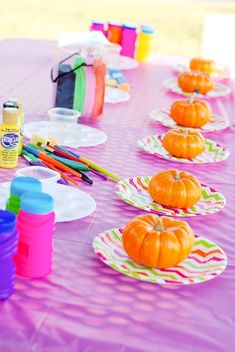 the table is set up with many plates and paintbrushes for kids to use