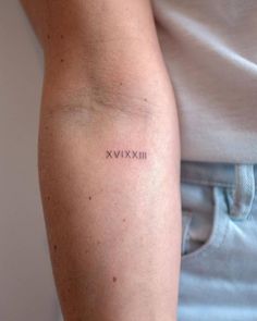 a woman's arm with the word xxvix tattooed on her left arm