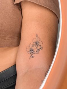 a woman's arm with a flower tattoo on the left side of her body