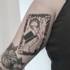 a woman's arm with a black and white tattoo design on the left arm