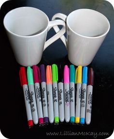 coffee mugs and markers are sitting on a table