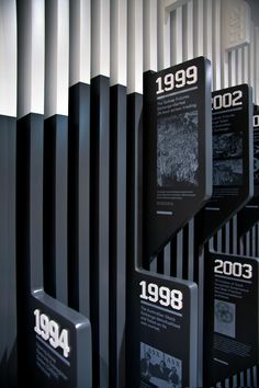 several black and white plaques on display in front of a metal wall with the year 1994