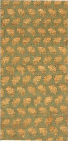 a green and gold wallpaper with small flowers on the top, in an ornate pattern